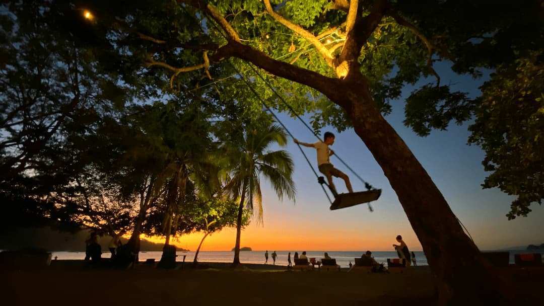 Swinging at sunset in Playa Hermosa, Guanacaste, Costa Rica